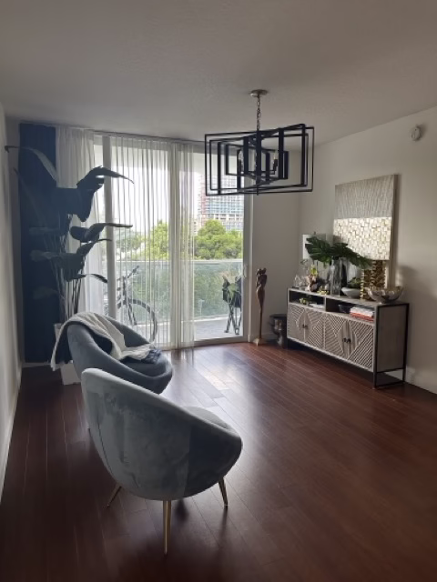 Bright apartment living room with balcony view and polished wood floors
